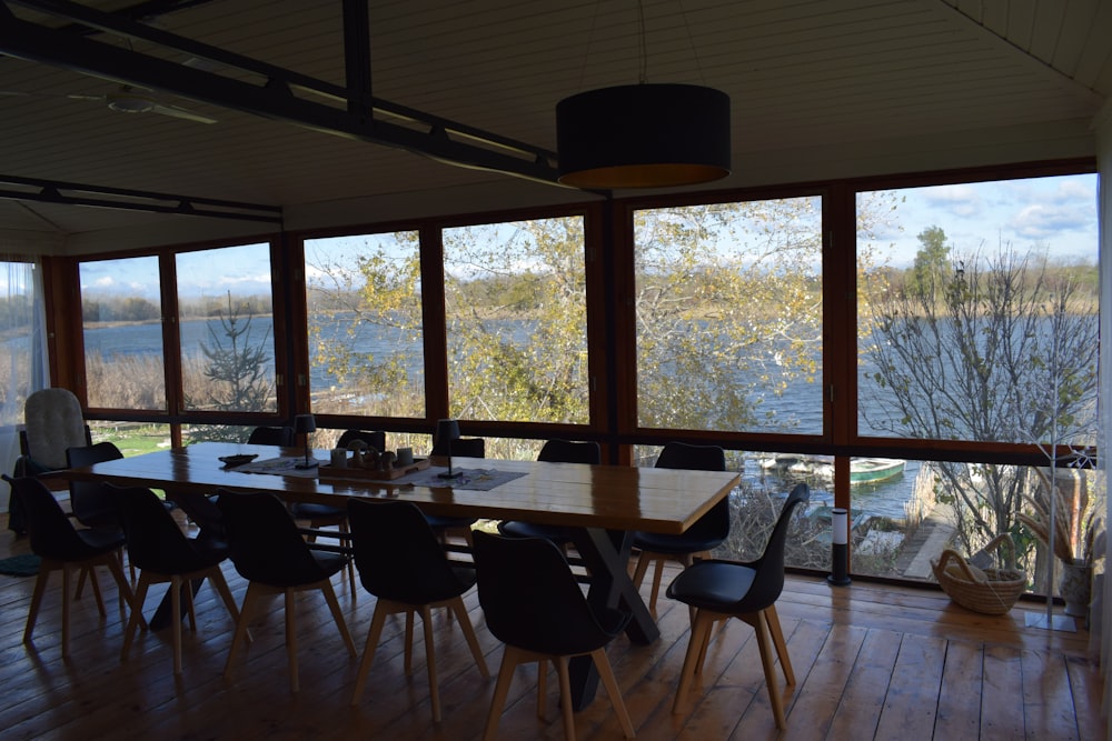 a dining room table with chairs and a view of a lake