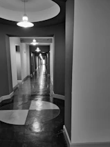 High-contrast image of a sophisticated hallway featuring bespoke lighting and flawless surfaces.