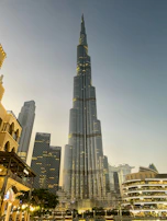 A modern skyscraper rising above the city skyline during golden hour, symbolizing growth and ambition.
