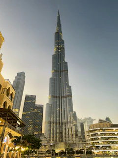 A modern skyscraper rising above the city skyline during golden hour, symbolizing growth and ambition.