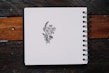 a notebook with a drawing of flowers on it