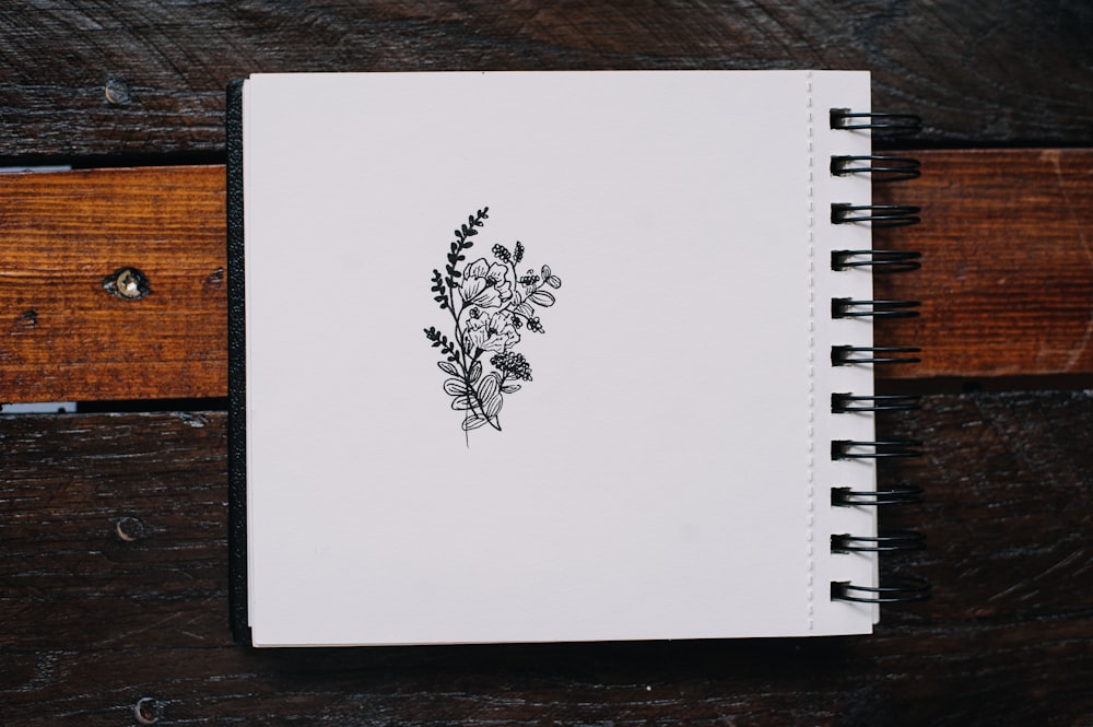 a notebook with a drawing of flowers on it