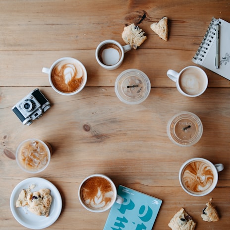 An artistically arranged table with coffee and art supplies.