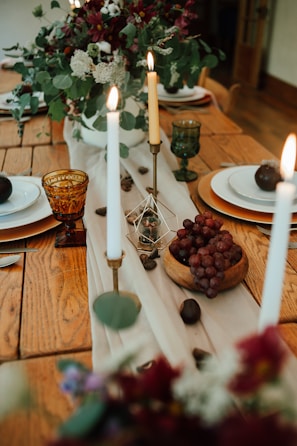 A dining area with a handcrafted wooden table adorned with fresh flowers and candles.