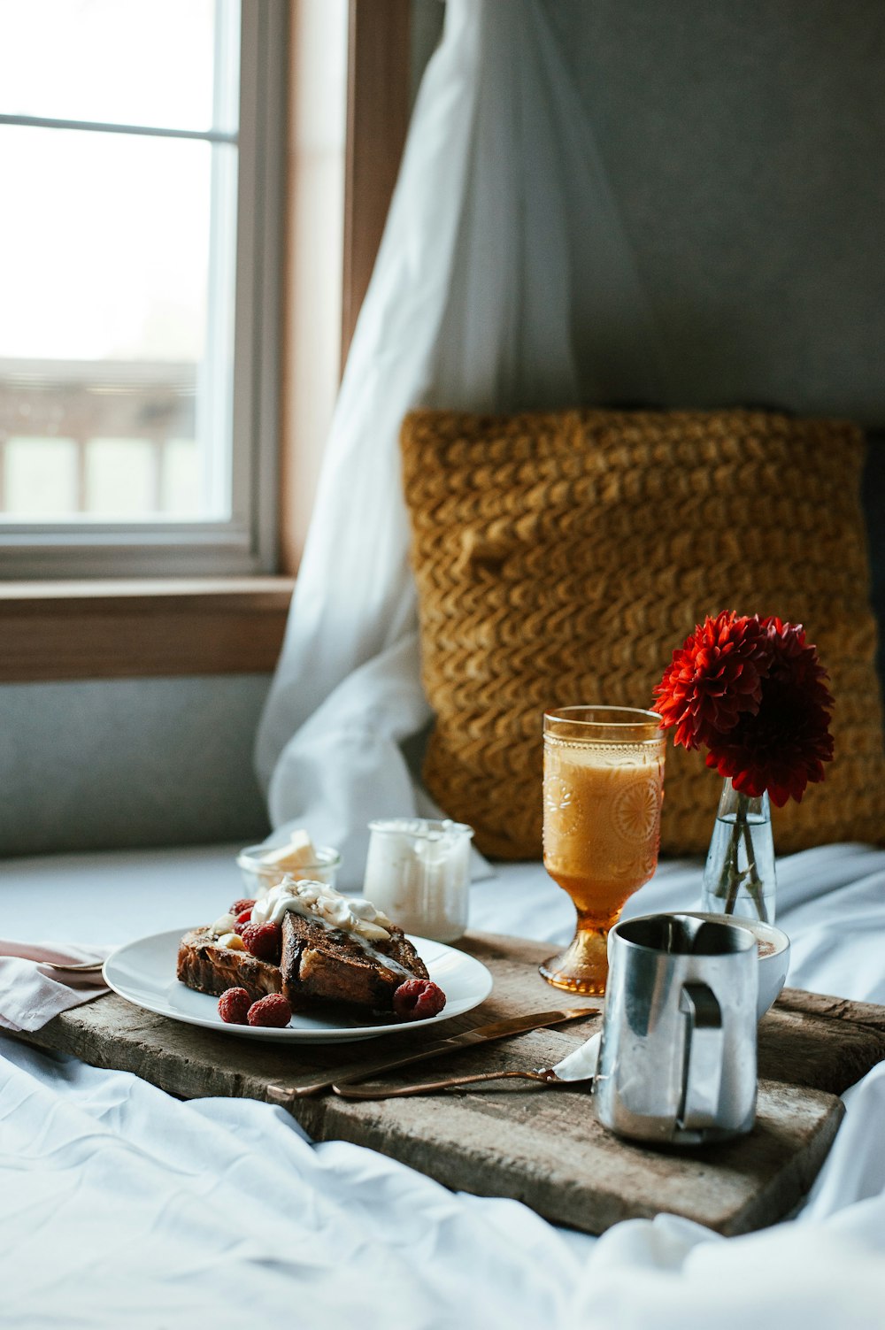 a tray with a plate of food and a glass of orange juice