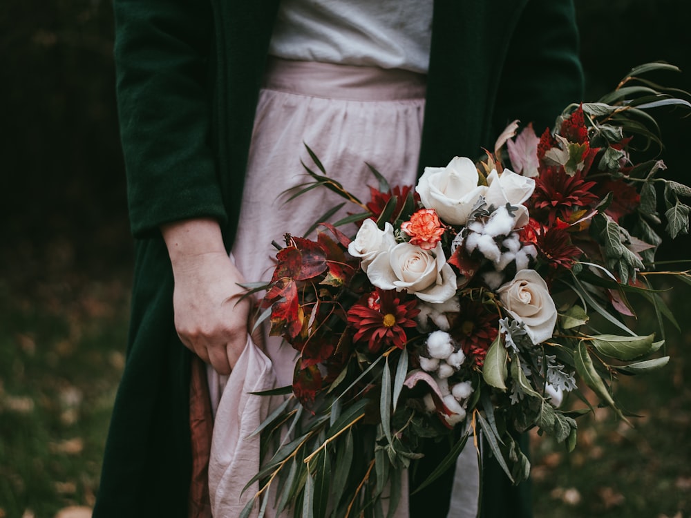 a woman holding a bouquet of flowers in her hands