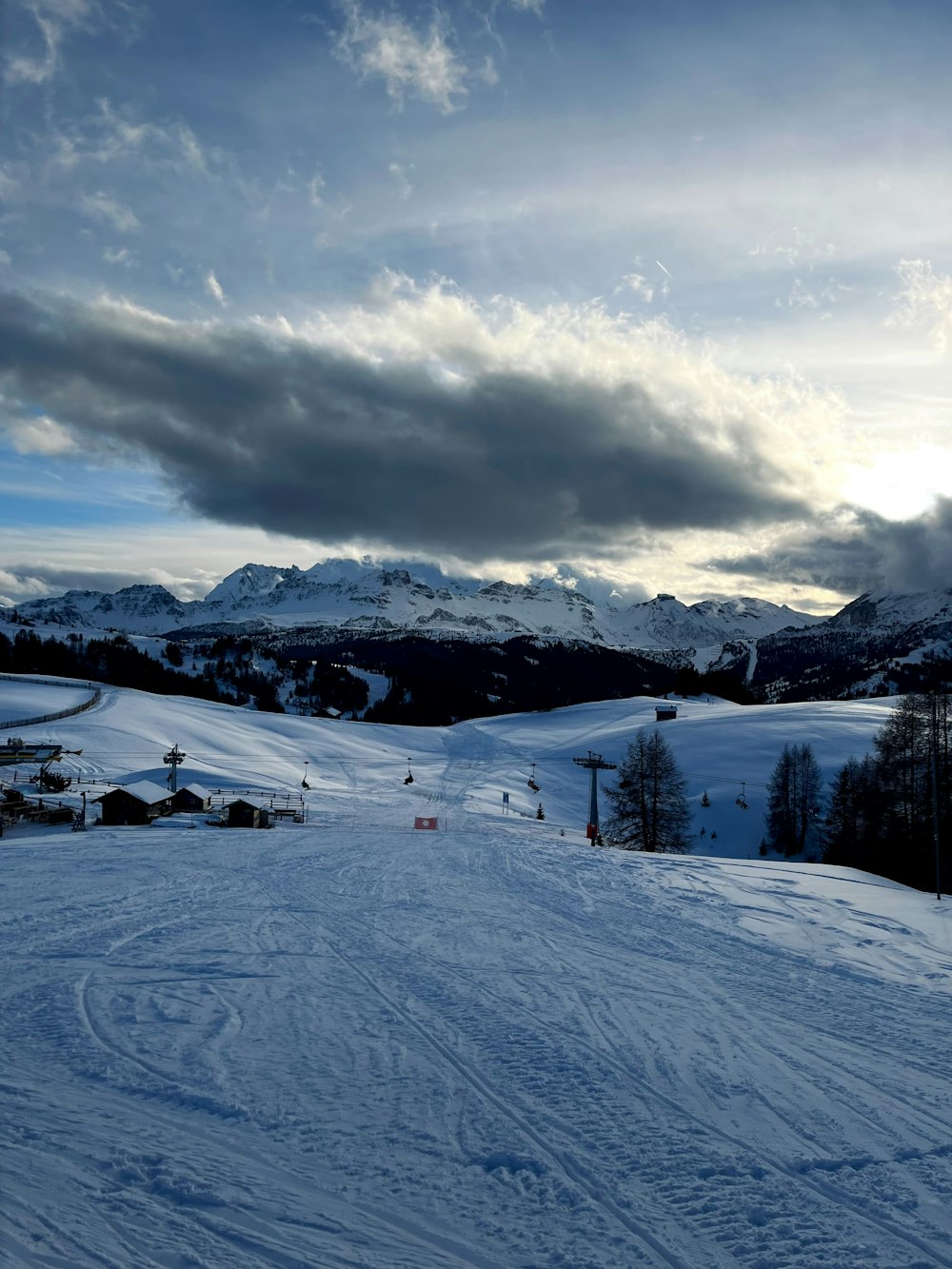 a snow covered ski slope with mountains in the background