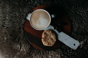 Tray of golden-brown cookies with chocolate chips and a cup of coffee beside them