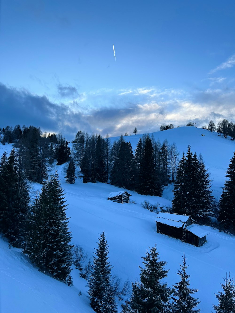 a snow covered mountain with a cabin in the distance