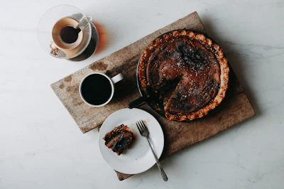 A cozy kitchen table scattered with pie slices and tasting notes.