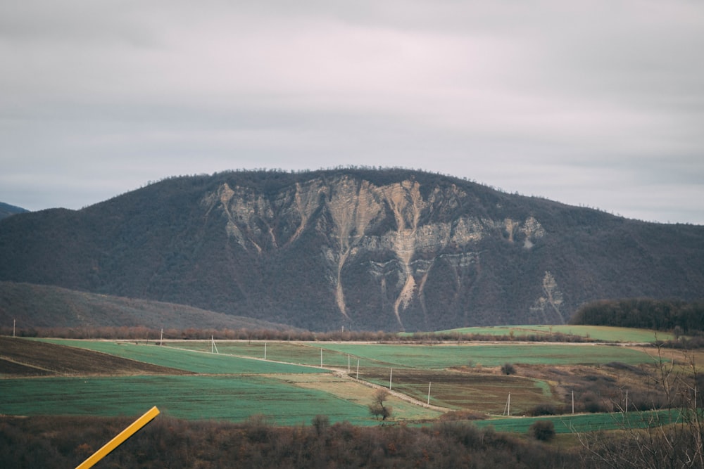 a view of a mountain with a yellow pole in the foreground