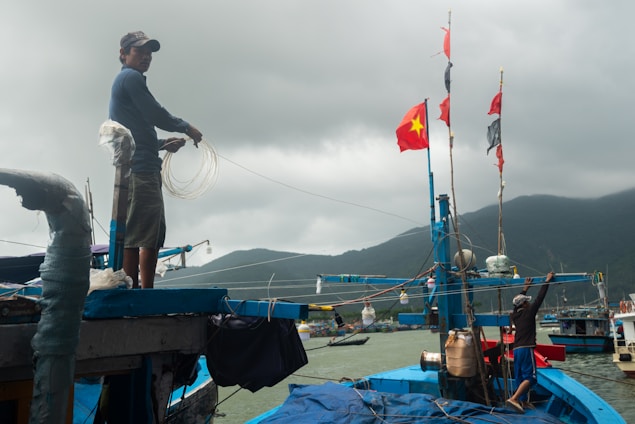 Fishermen and women working together on a small boat near vibrant coral reefs in Zanzibar.