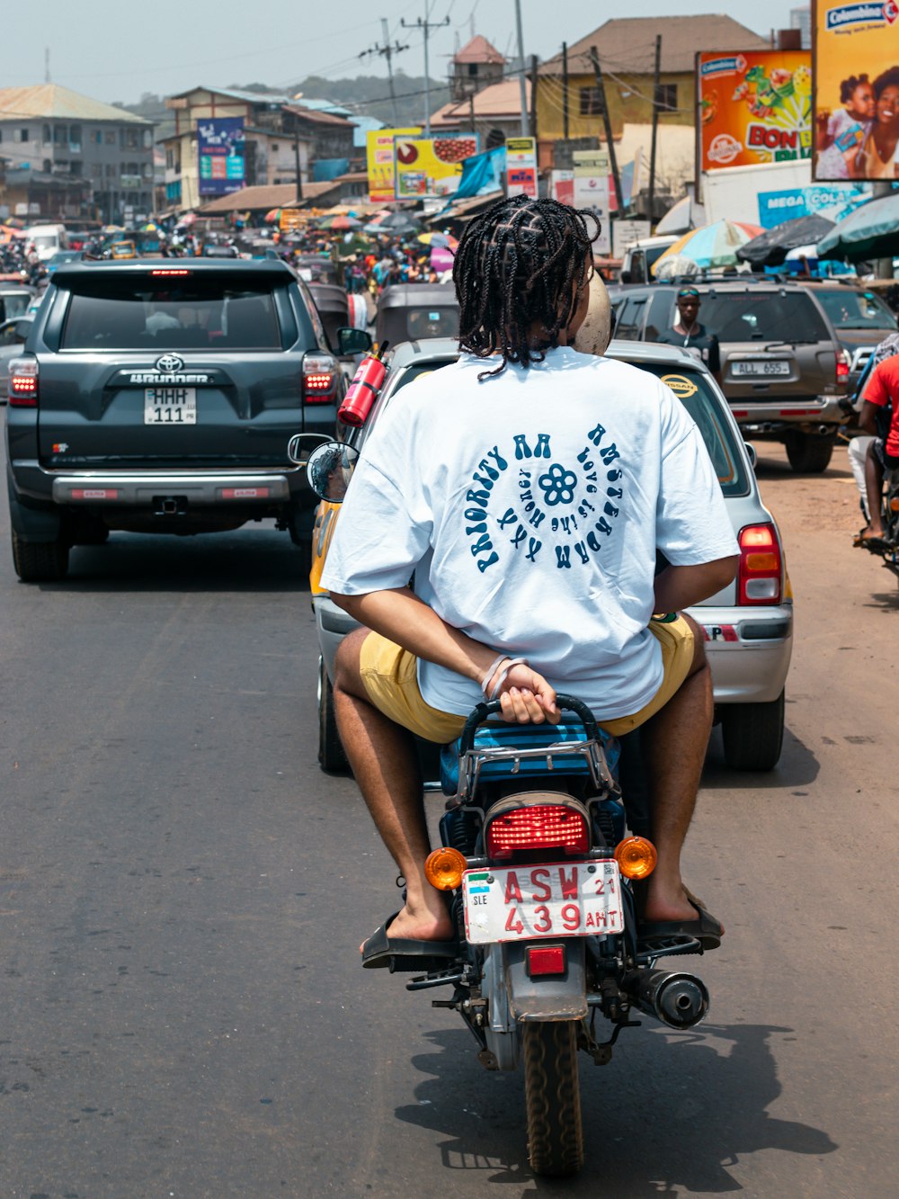 a man riding a motorcycle down a busy street