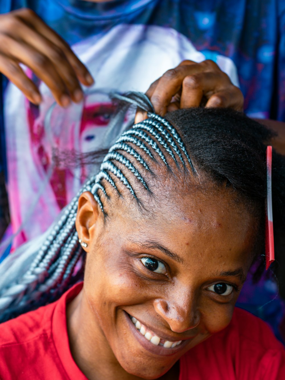 a woman smiling while getting her hair cut
