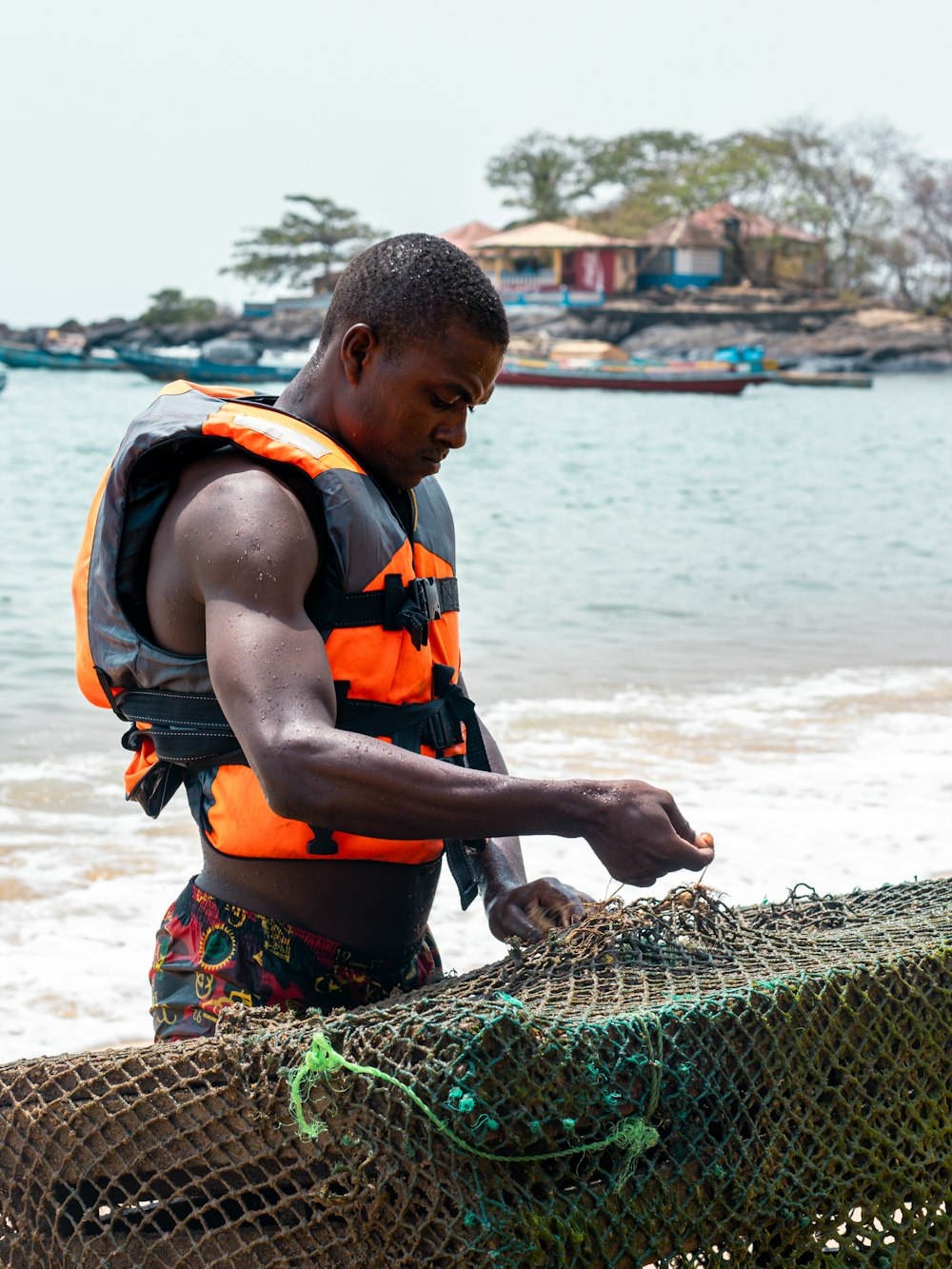 a man in a life jacket pulling a fishing net out of the water