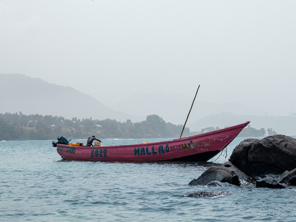 a red boat with people in it on a body of water