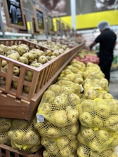 Interior view of a cold storage facility filled with crates of fresh potatoes and onions.