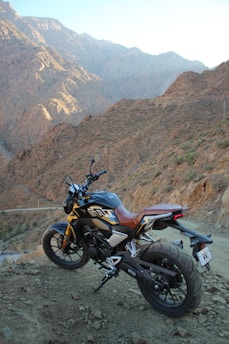 A rugged KTM 1290 Super Adventure parked on a mountain road at sunset.