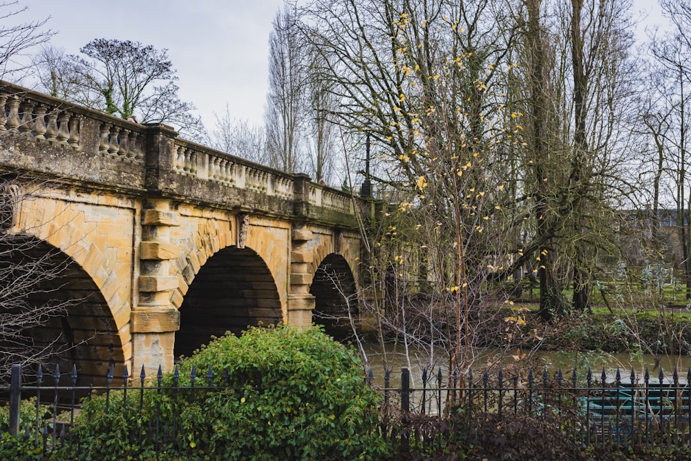 a stone bridge over a river with trees in the background