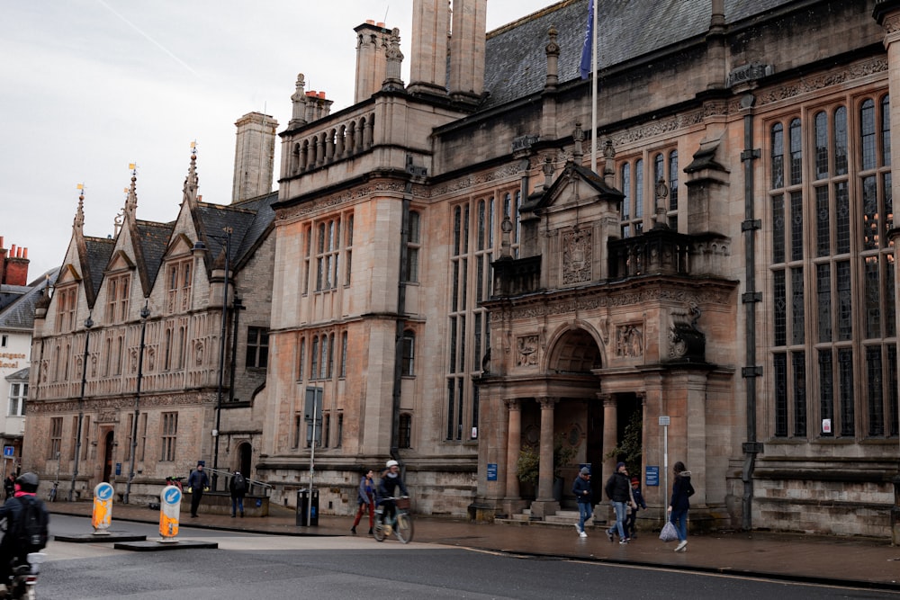 a group of people walking in front of a large building