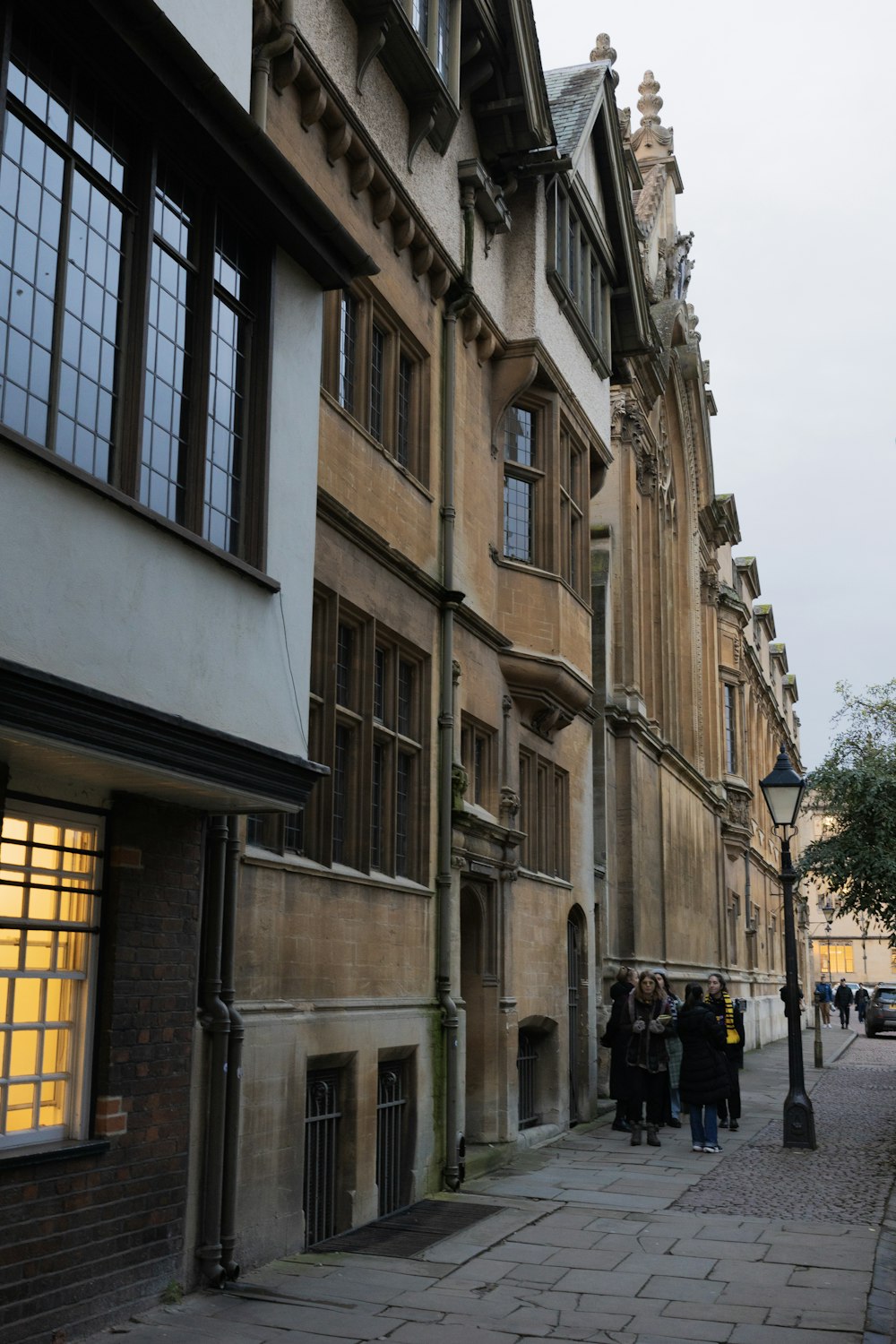 a group of people walking down a street next to tall buildings