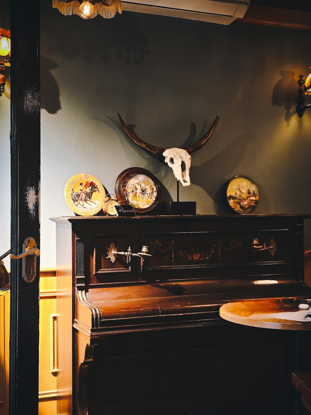 a room with a piano and a skull on the wall