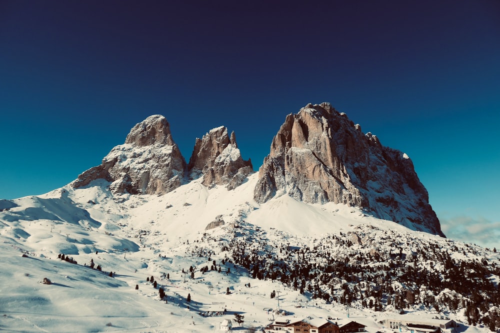 a snow covered mountain with a small cabin in the foreground