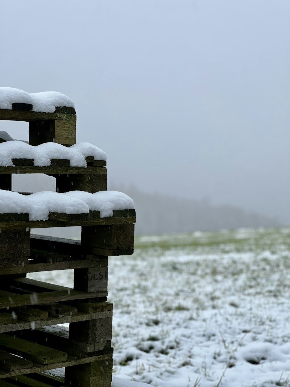 a pile of wooden crates covered in snow