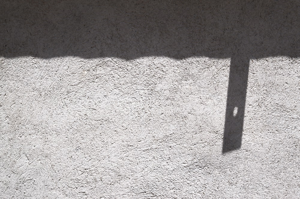 a shadow of a clock on a wall