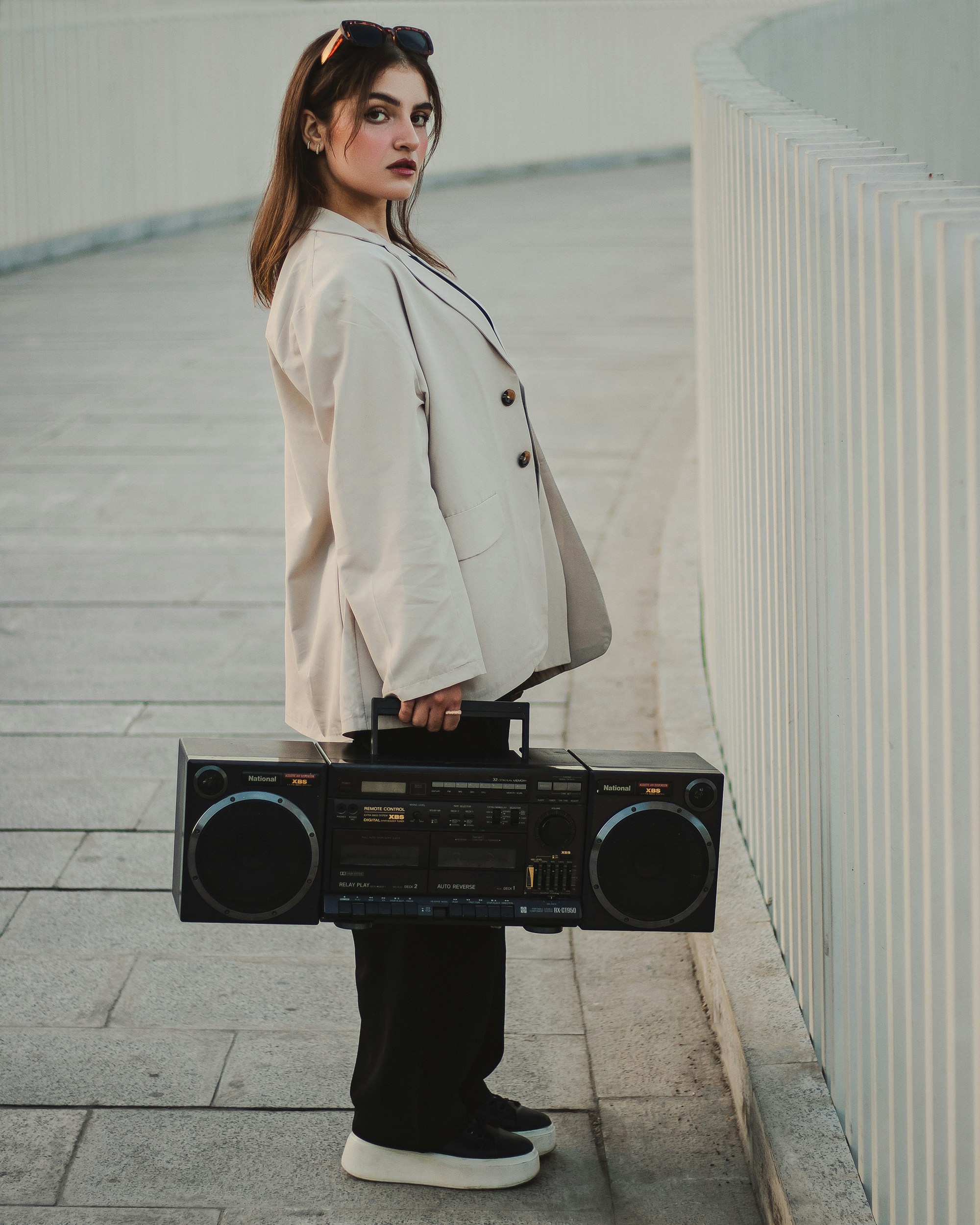a woman is holding a boombox and wearing sunglasses
