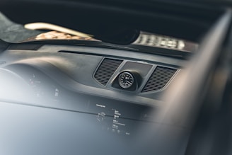 Close-up of a modern car dashboard clock glowing softly in blue light.