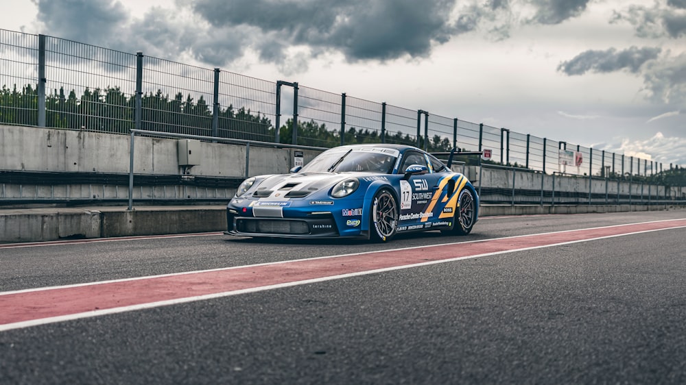 a blue race car driving down a race track