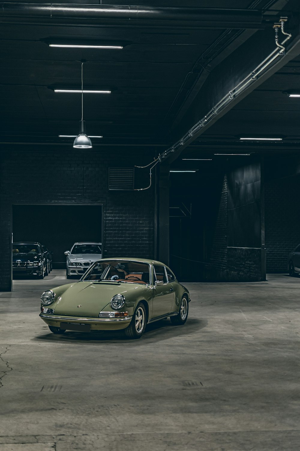 a green car parked in a garage next to other cars