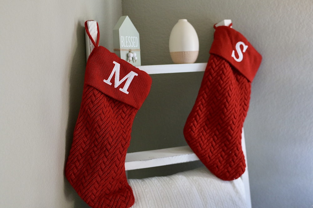 a red christmas stocking hanging on a white shelf