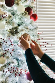 A close-up of hands crafting holiday decorations with natural materials.