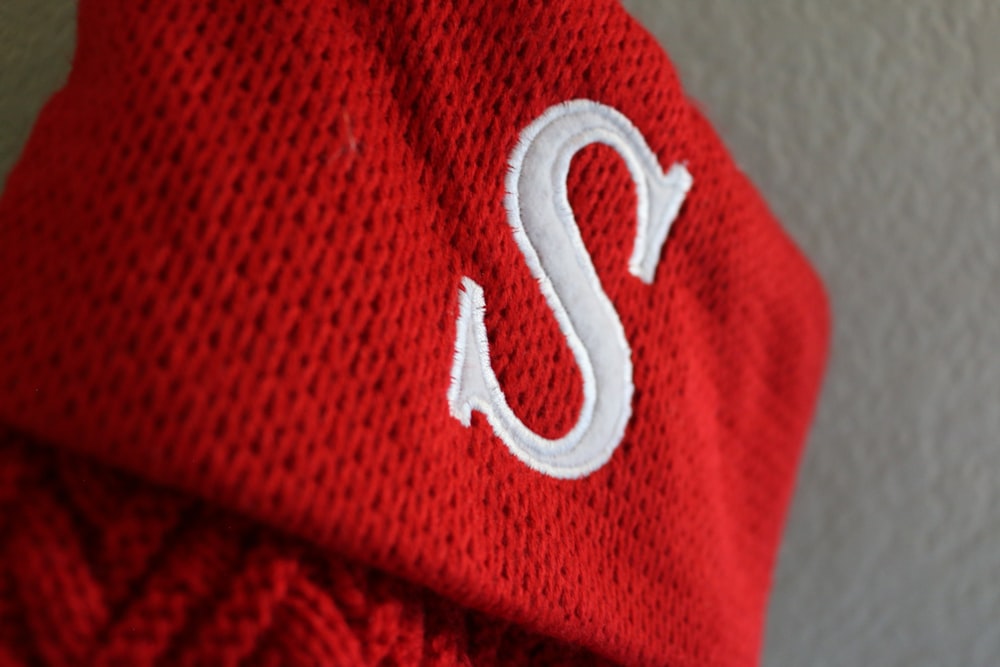a red hat with a white s on it