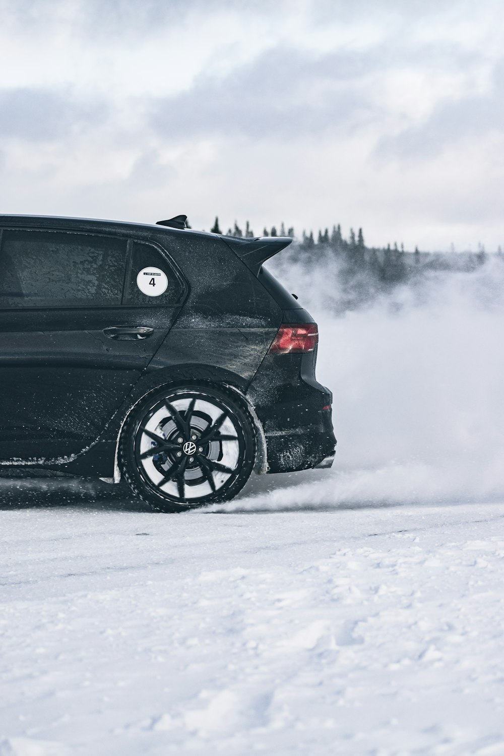 a black car driving on a snowy road