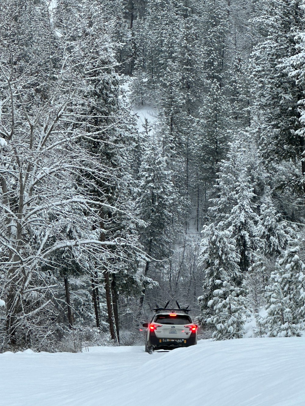 a car driving down a snow covered road