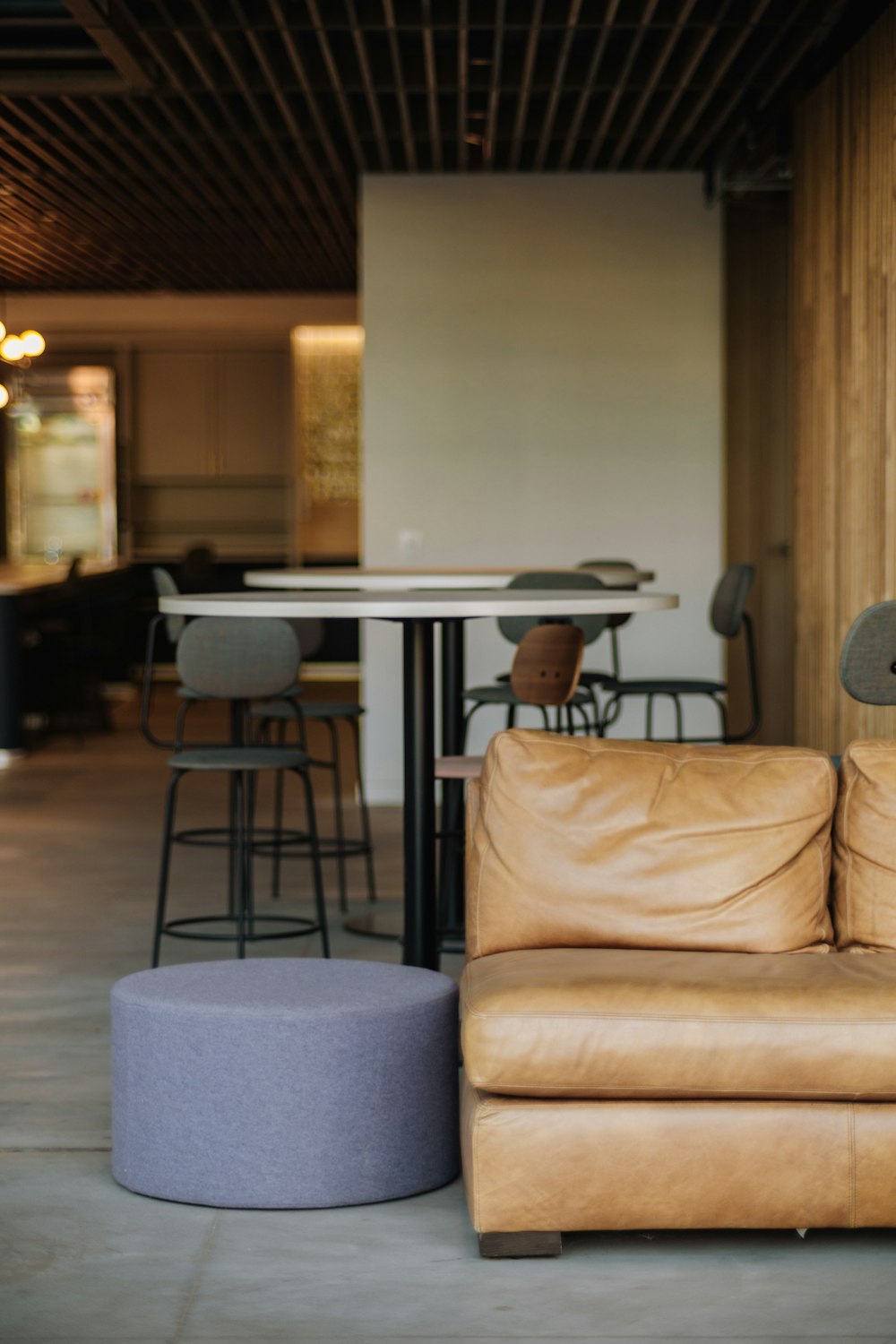 a tan leather couch sitting in a living room next to a table