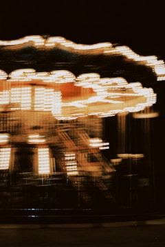 A sleek, dark-themed carousel of rotating creator portraits with crimson highlights.