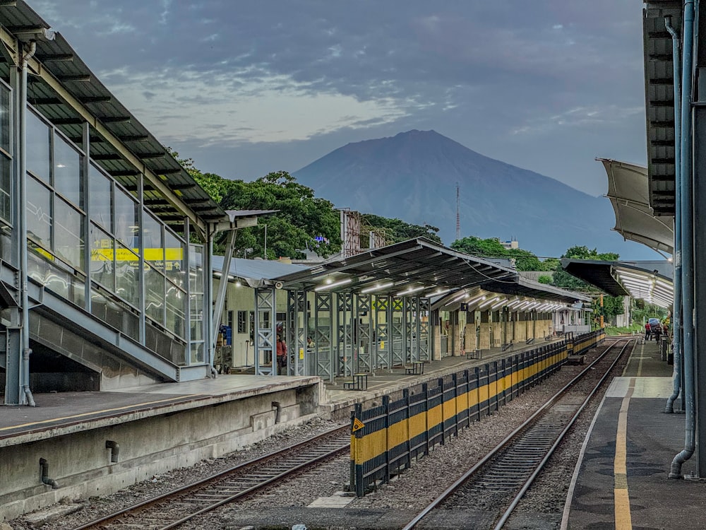 a train station with a mountain in the background