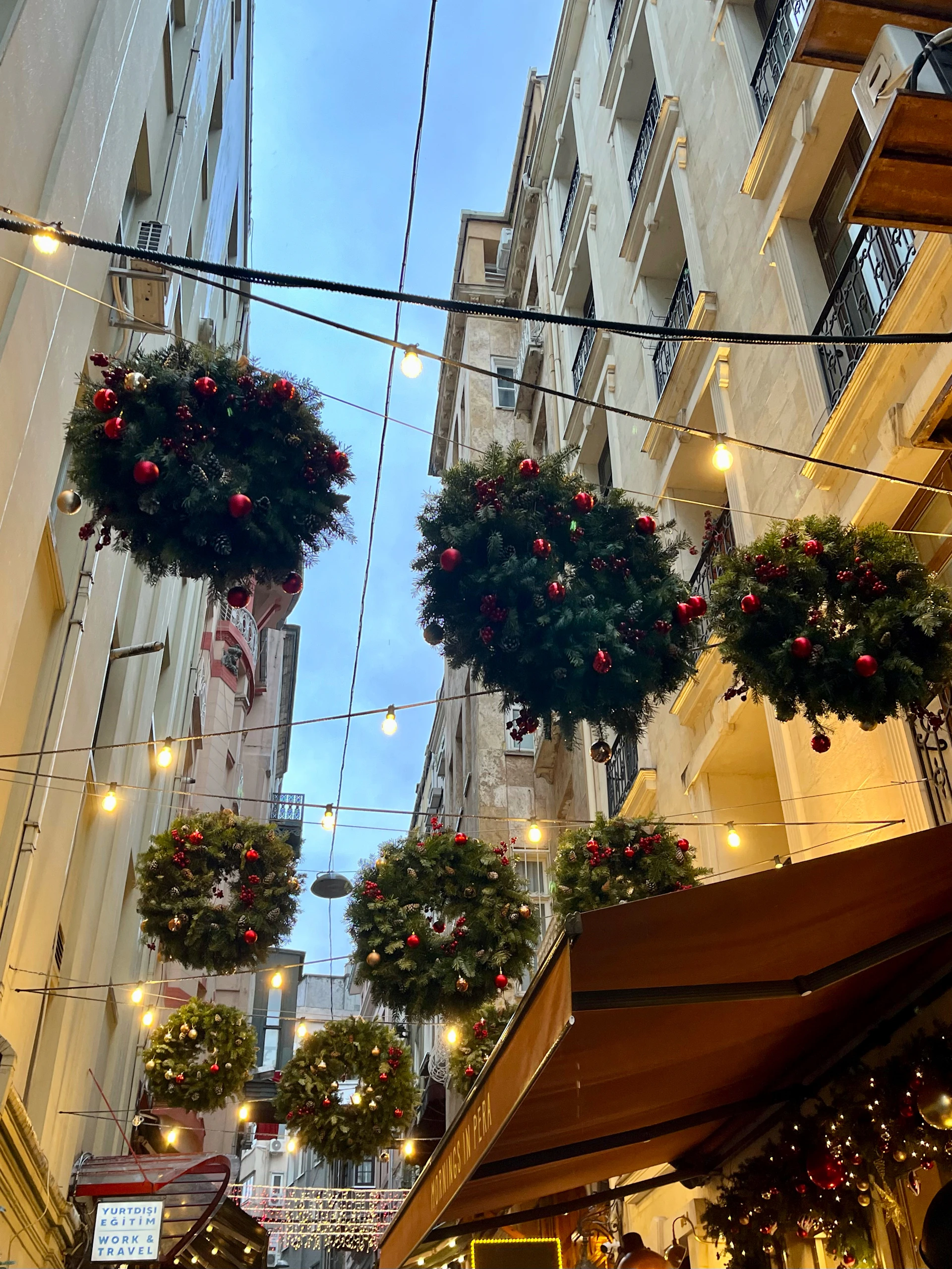 A charming neighborhood street lined with homes beautifully decorated with vibrant holiday lights and illuminated wreaths.