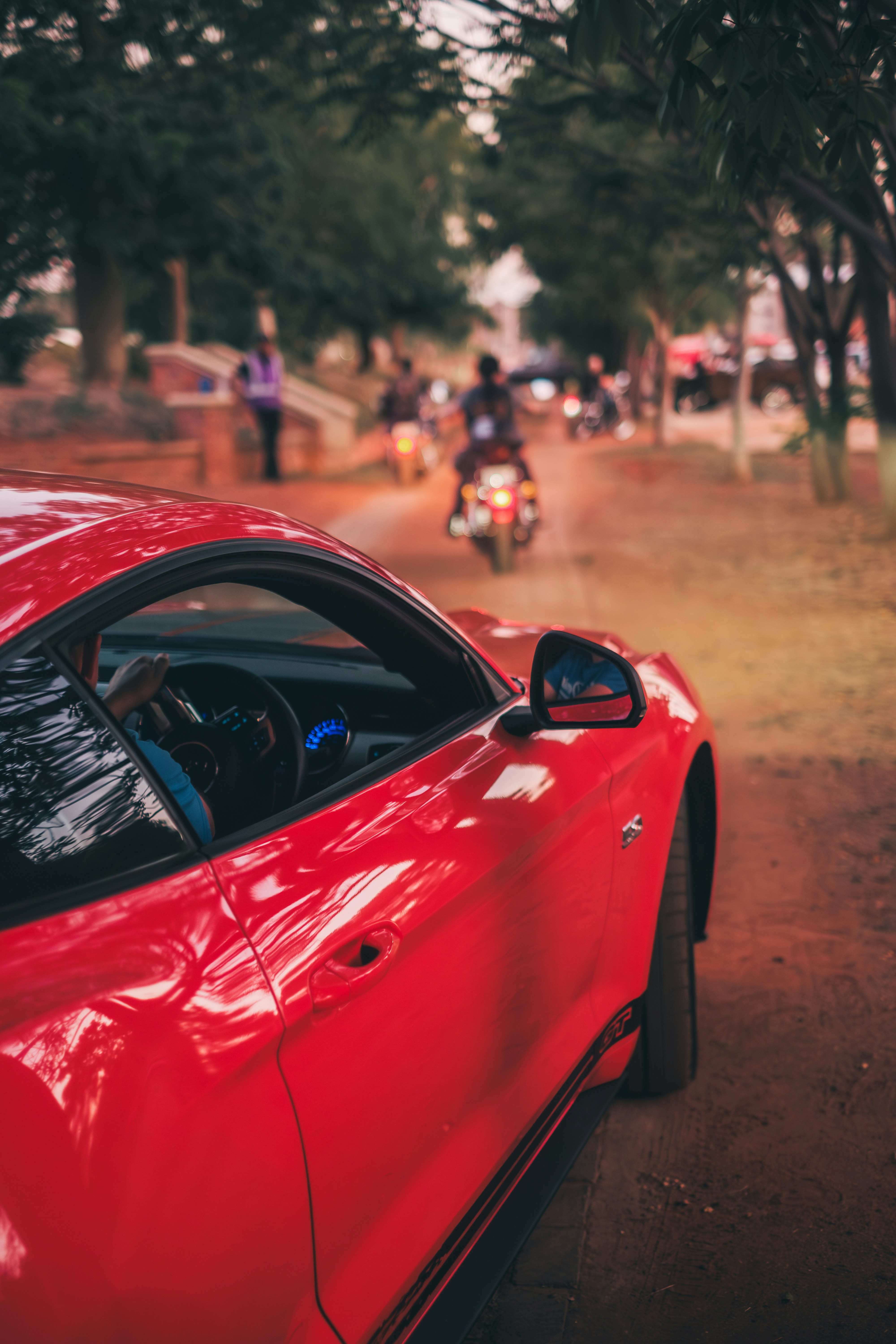 um carro esportivo vermelho estacionado na beira da estrada