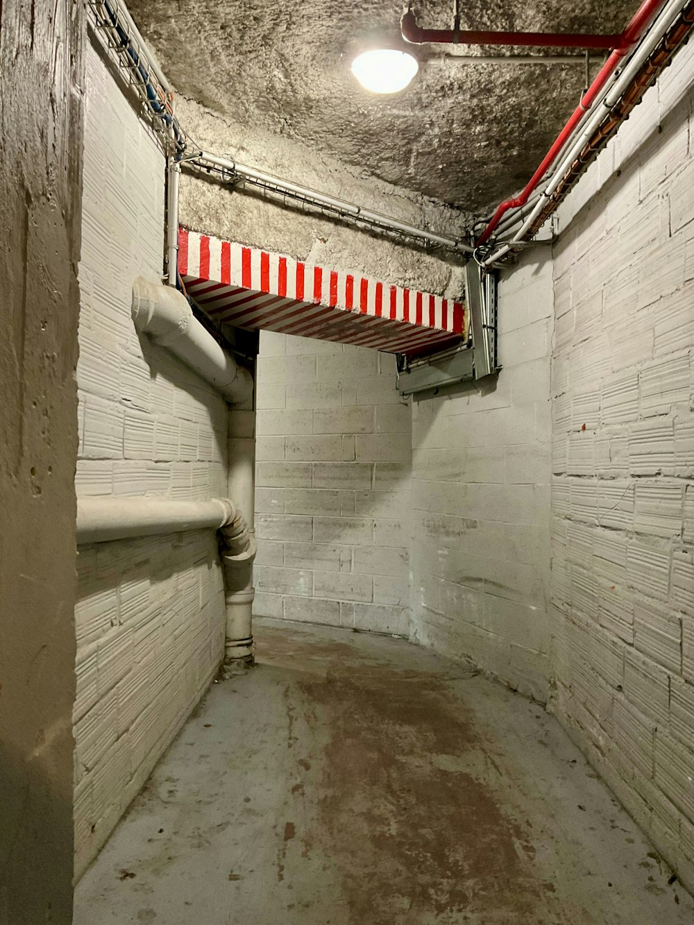 a long narrow room with a red and white striped awning