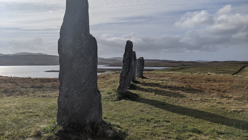 a group of large rocks sitting on top of a grass covered field