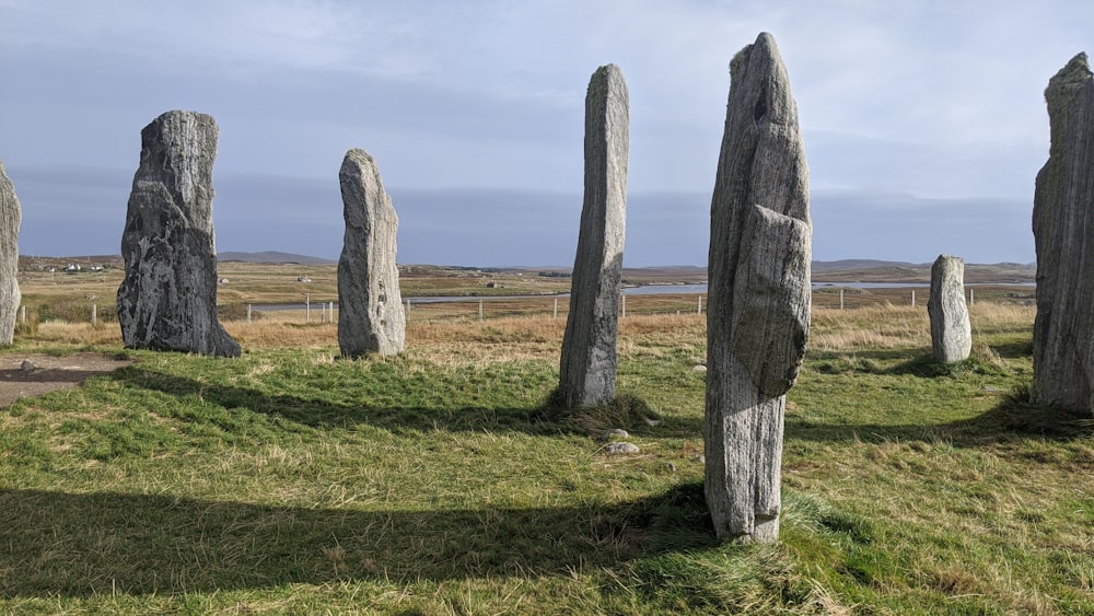 a group of large rocks sitting on top of a grass covered field