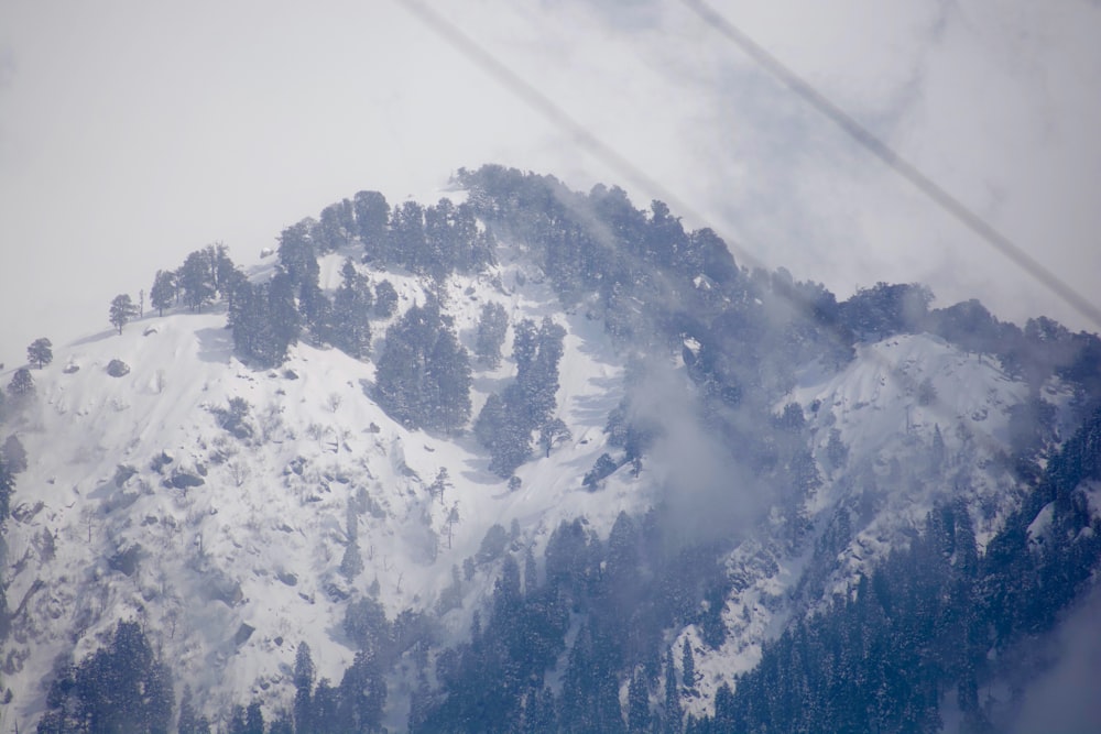 a mountain covered in snow with a ski lift in the background