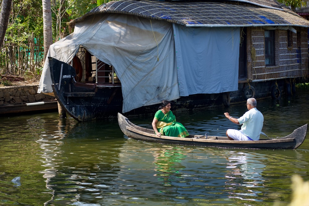 a man and a woman sitting in a boat on a river