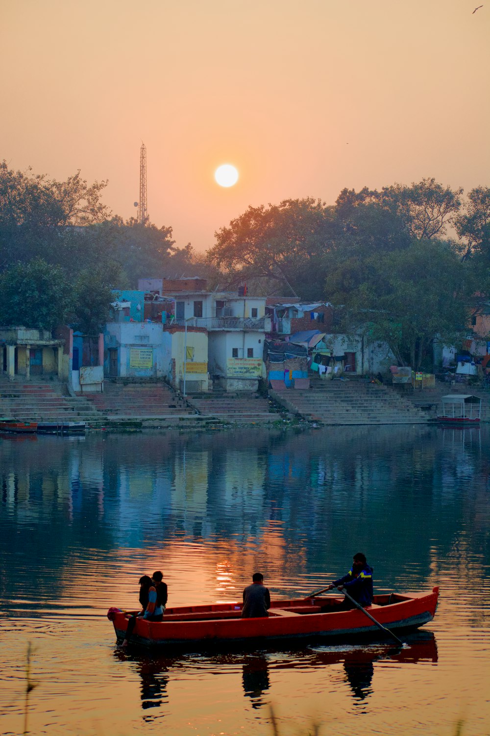 a couple of people in a red boat on a body of water