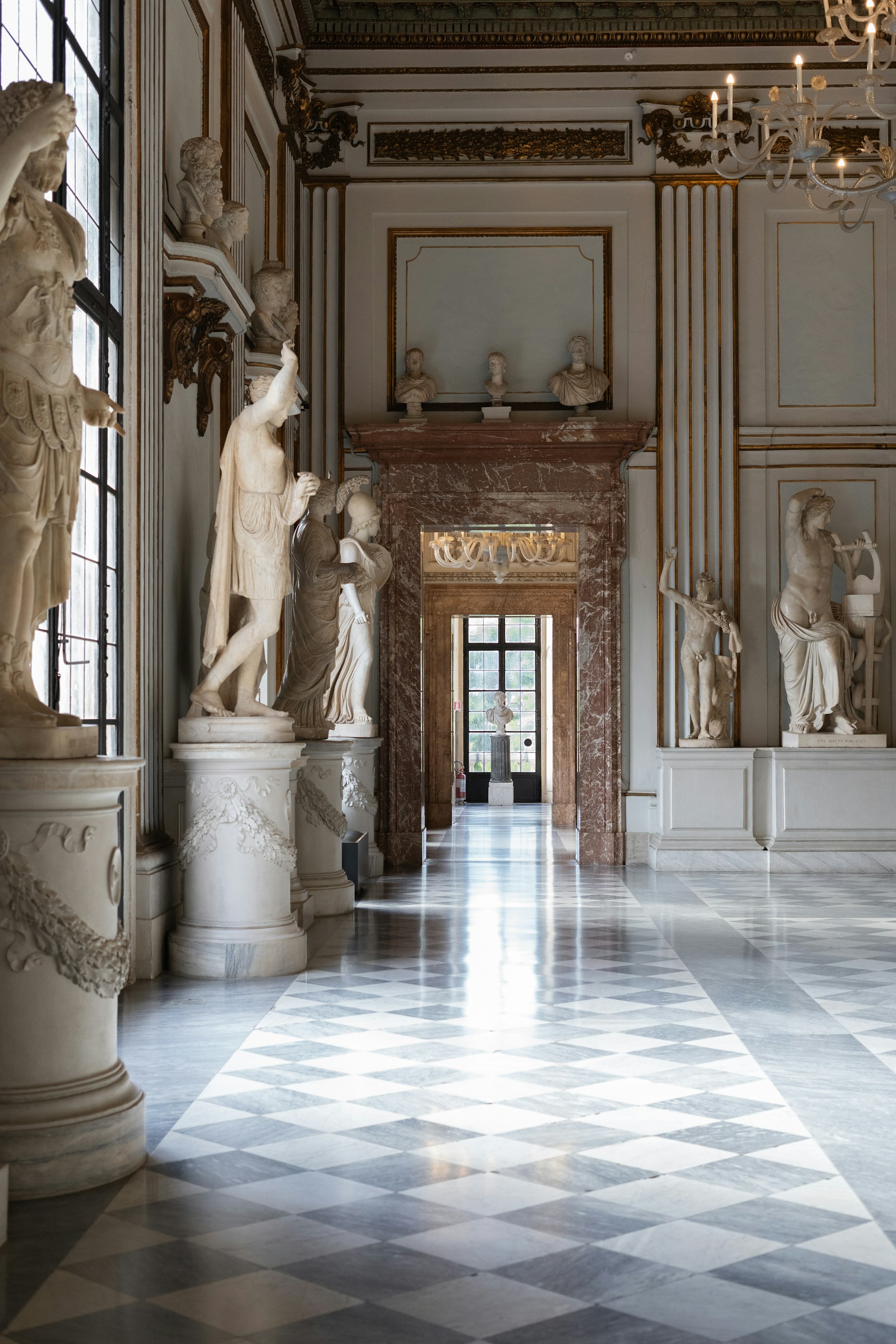 a room with statues and chandeliers in it